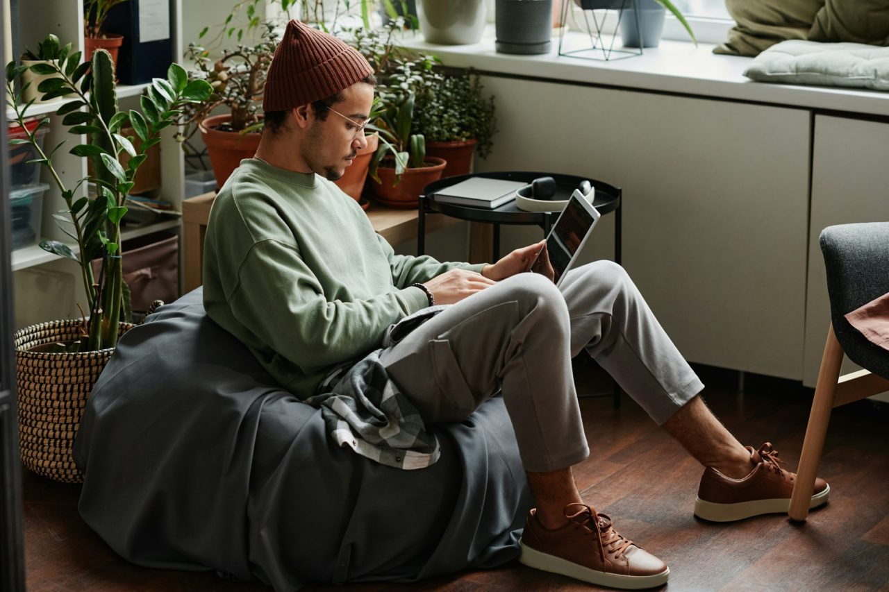 Young serious webdesigner with laptop concentrating on network